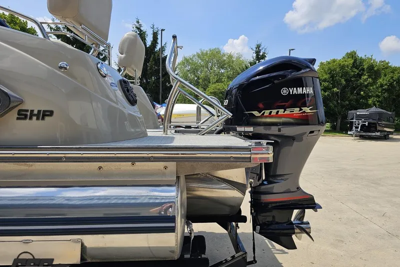 Slide: The Image of 2016 Manitou 23 Legacy boat with Yamaha VMAX outboard motor, parked outdoors. - 40