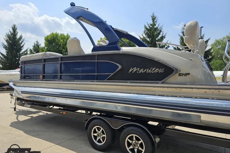 Slide: The Image of 2016 Manitou 23 Legacy pontoon boat on trailer, featuring sleek design and blue accents. - 41
