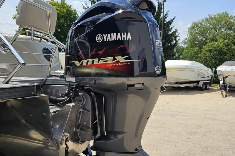 Slide: The Image of 2016 Manitou 23 Legacy with Yamaha VMAX outboard motor in a boatyard setting. - 44
