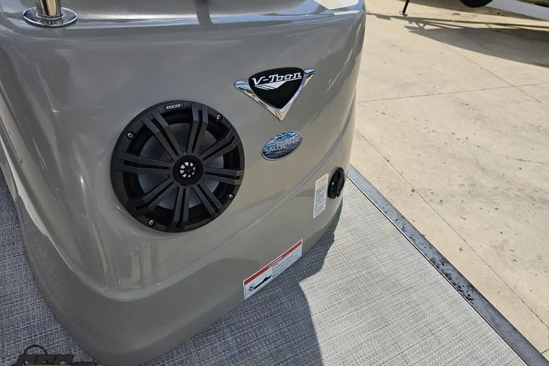 Slide: The Image of 2016 Manitou 23 Legacy boat with Kicker speaker and V-Toon technology badge. - 55