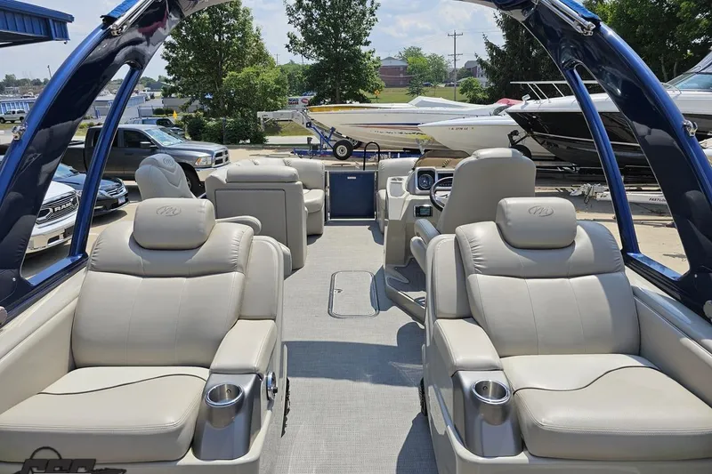Slide: The Image of 2016 Manitou 23 Legacy pontoon boat interior with luxurious seating and cup holders. - 61