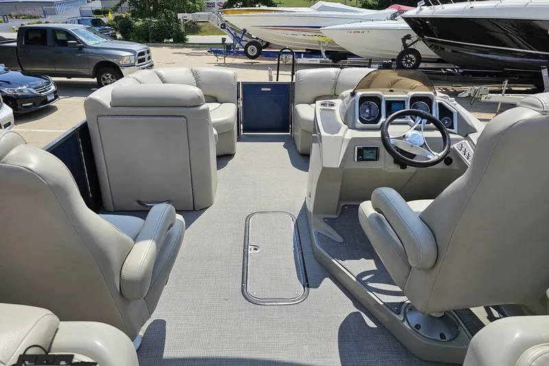 Slide: The Image of 2016 Manitou 23 Legacy pontoon boat interior with plush seating and modern dashboard. - 64