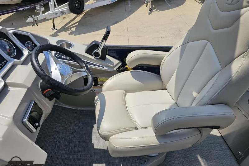 Slide: The Image of 2016 Manitou 23 Legacy boat cockpit with steering wheel and comfortable captain's chair. - 66
