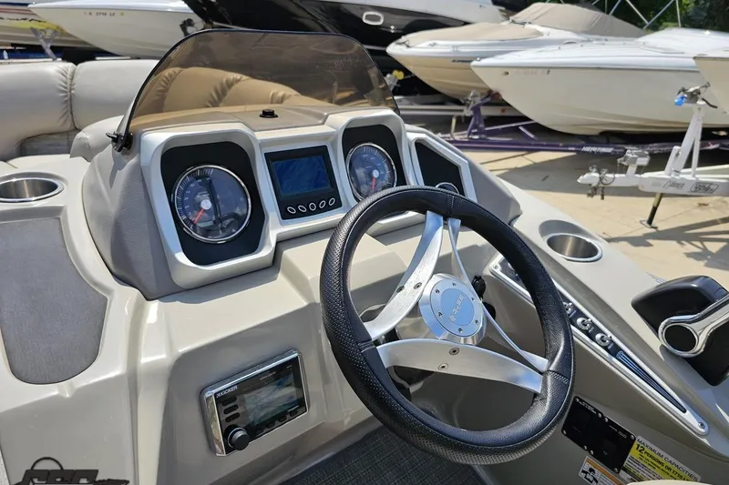 Slide: The Image of Steering console of 2016 Manitou 23 Legacy boat with gauges and controls. - 67