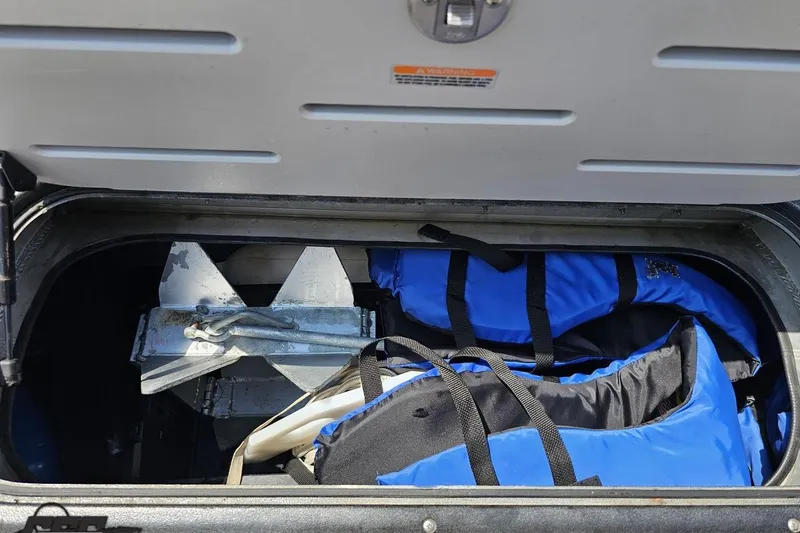 Slide: The Image of Storage compartment of 2016 Manitou 23 Legacy with anchor and blue life jackets. - 76