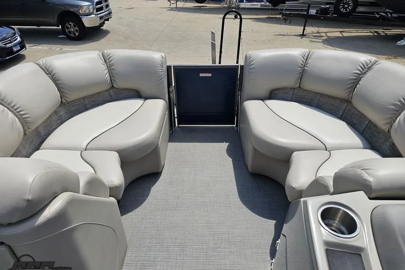 Slide: The Image of 2016 Manitou 23 Legacy boat interior with plush seating and cup holders. - 78