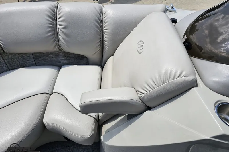 Slide: The Image of 2016 Manitou 23 Legacy boat interior with plush gray seating and armrest. - 81