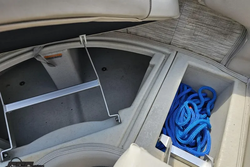 Slide: The Image of 2016 Manitou 23 Legacy boat storage compartment with blue rope. - 83