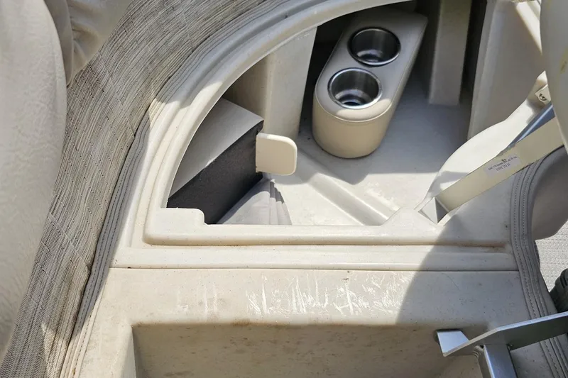 Slide: The Image of Interior of 2016 Manitou 23 Legacy boat with cup holders and storage compartment. - 86
