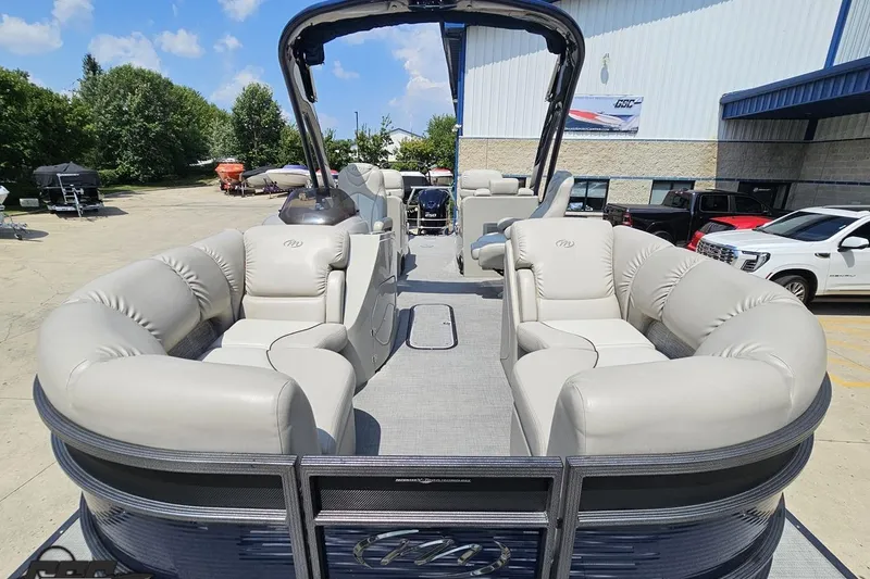 Slide: The Image of 2016 Manitou 23 Legacy pontoon boat with plush seating, parked outdoors. - 88