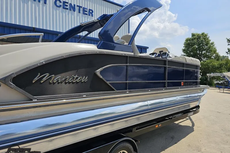 Slide: The Image of 2016 Manitou 23 Legacy pontoon boat parked outside a marine center. - 9