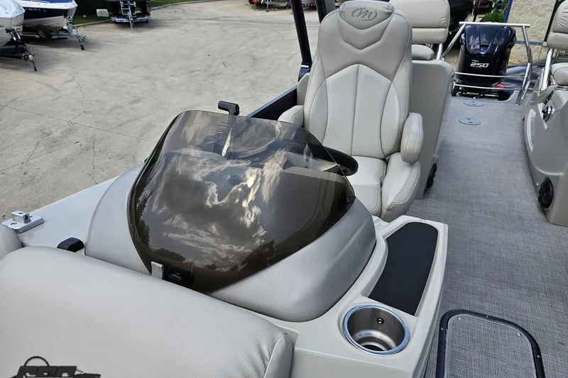Slide: The Image of 2016 Manitou 23 Legacy boat interior with captain's chair and console, featuring sleek design. - 91
