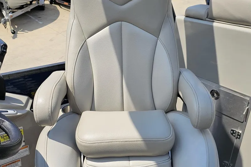 Slide: The Image of Luxurious captain's chair in 2016 Manitou 23 Legacy boat, featuring plush gray upholstery. - 93