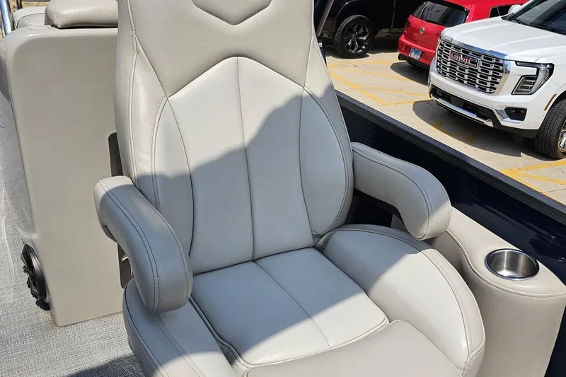 Slide: The Image of Luxurious seating in 2016 Manitou 23 Legacy boat, featuring plush armrests and cup holder. - 94