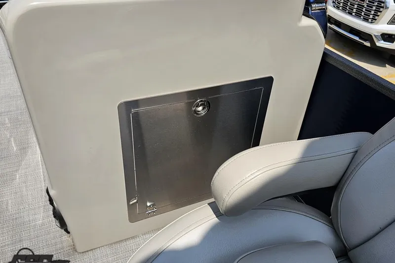 Slide: The Image of 2016 Manitou 23 Legacy boat interior with storage compartment and cushioned seating. - 97