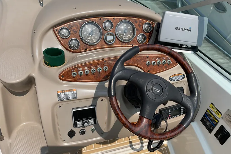 Slide: The Image of 2003 Maxum 2700 SCR boat dashboard with Garmin GPS and wood-trimmed steering wheel. - 11