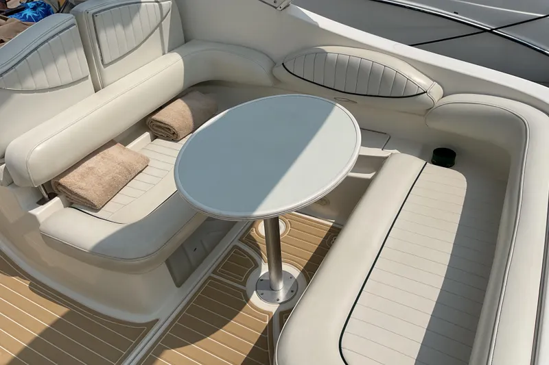 Slide: The Image of 2003 Maxum 2700 SCR boat interior with white seating and round table. - 12