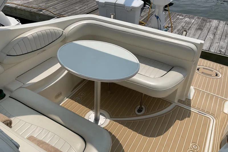 Slide: The Image of 2003 Maxum 2700 SCR boat interior with round table and cushioned seating. - 13