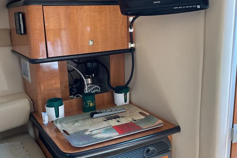 Slide: The Image of 2003 Maxum 2700 SCR cabin interior with TV, wooden cabinetry, and countertop accessories. - 19