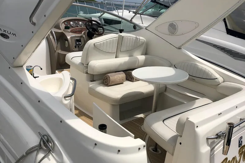 Slide: The Image of 2003 Maxum 2700 SCR boat interior with plush seating, table, and helm. - 4