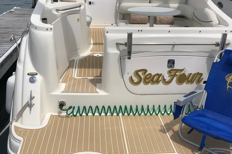 Slide: The Image of 2003 Maxum 2700 SCR boat deck with seating, table, and "Sea Four" name. - 5