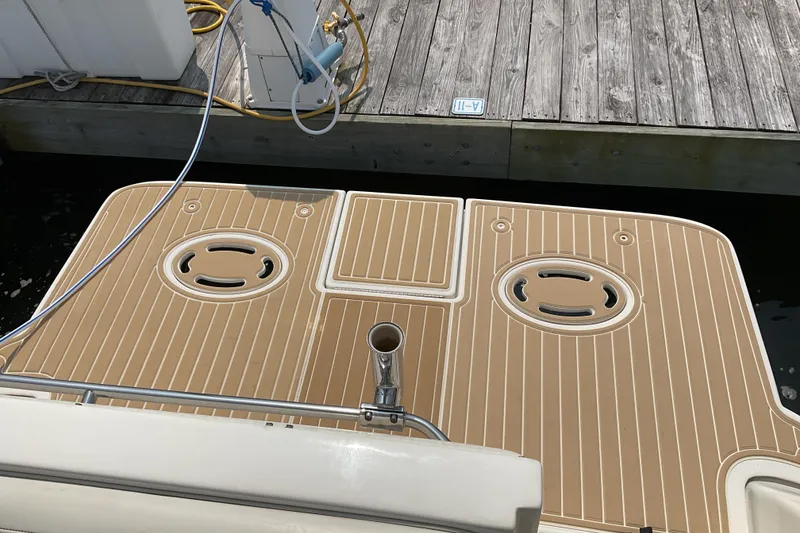 Slide: The Image of 2003 Maxum 2700 SCR boat deck with tan non-slip surface near wooden dock. - 6