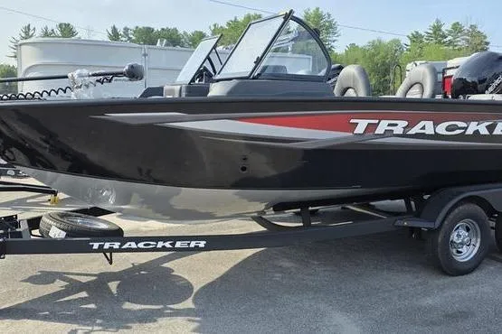 The Image of 2026 Tracker Targa V18 Combo boat on trailer, black with red accents, parked outdoors. - 0