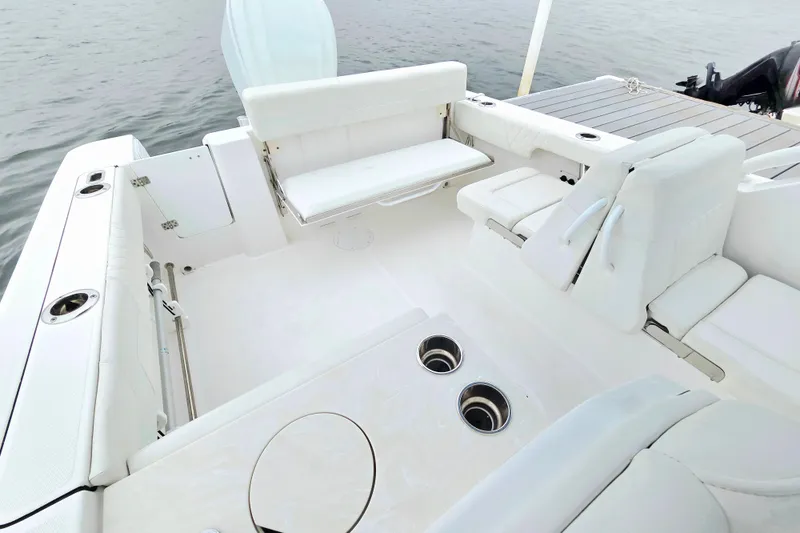 Slide: The Image of 2022 Edgewater 248 CX boat interior with white seating and cup holders. - 10