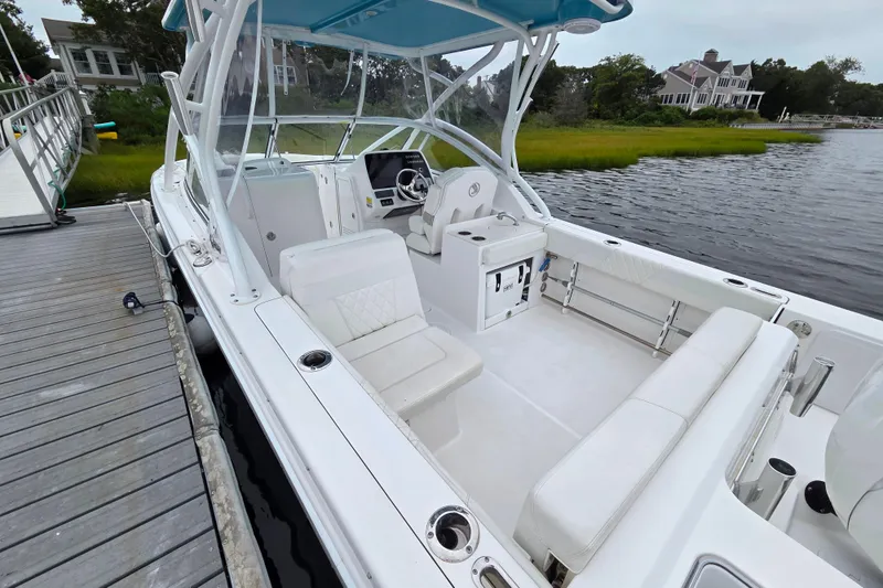 Slide: The Image of 2022 Edgewater 248 CX boat docked, featuring spacious seating and modern design. - 13