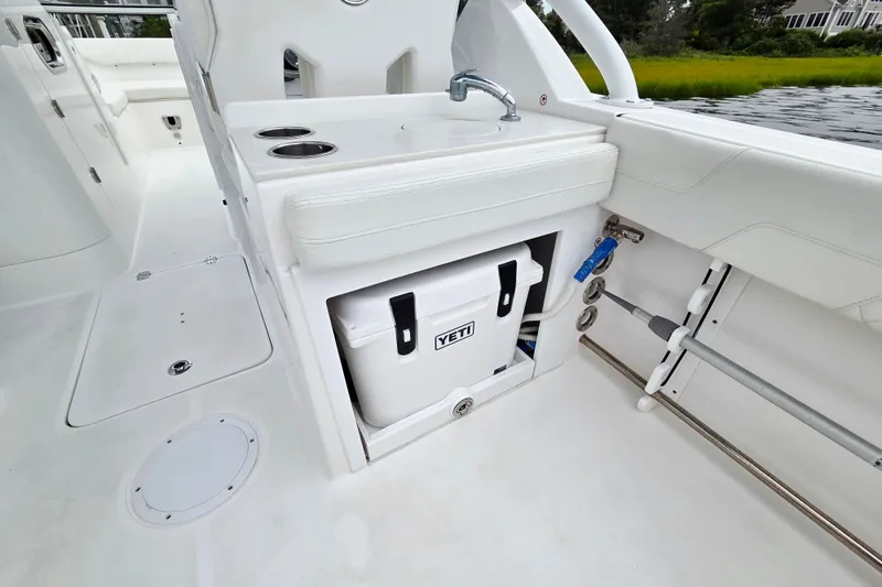 Slide: The Image of Edgewater 248 CX 2022 boat interior with sink, Yeti cooler, and rod holders. - 6