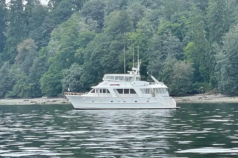 Slide: The Image of 2001 Rayburn Flush Deck yacht on open water, featuring wooden deck and clear blue sky. - 56