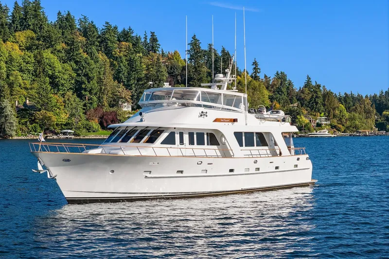 Slide: The Image of 2001 Rayburn Flush Deck yacht cruising on a serene lake with scenic shoreline. - 80