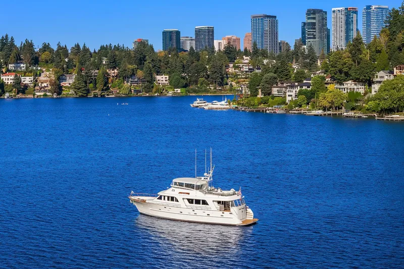 Slide: The Image of 2001 Rayburn Flush Deck yacht on a serene lake with clear blue skies. - 86