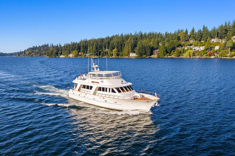 Slide: The Image of 2001 Rayburn Flush Deck yacht on a serene lake with city skyline backdrop. - 89