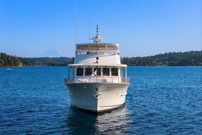 Slide: The Image of Front view of 2001 Rayburn Flush Deck yacht on a serene lake with forested shoreline. - 97