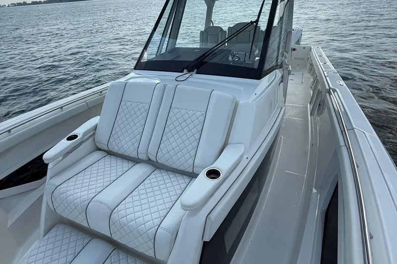 Slide: The Image of 2022 Pursuit S 378 Sport boat with luxurious white seating on calm water. - 10