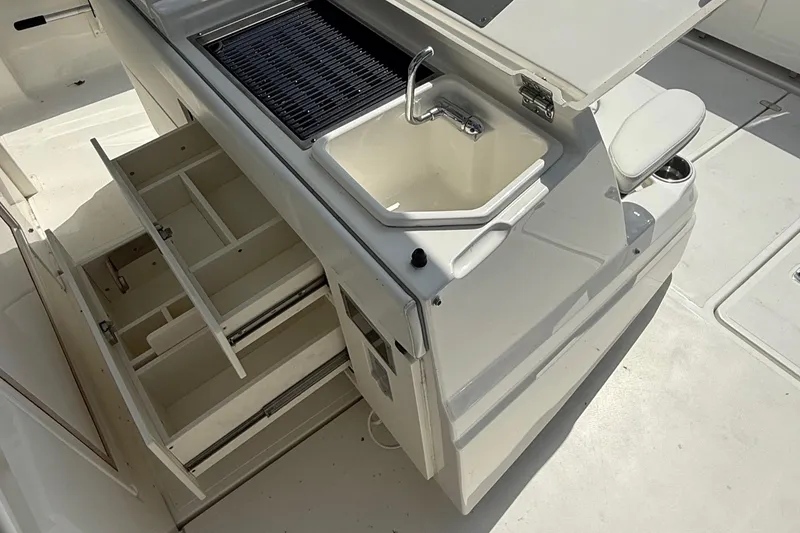 Slide: The Image of 2022 Pursuit S 378 Sport boat kitchen with sink, grill, and storage drawers. - 24