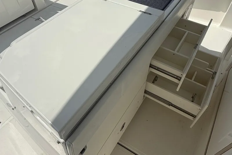 Slide: The Image of 2022 Pursuit S 378 Sport boat storage compartments with open drawers. - 25