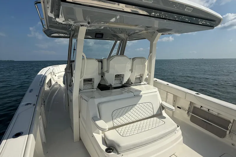 Slide: The Image of 2022 Pursuit S 378 Sport boat interior with seating, on calm ocean waters. - 28