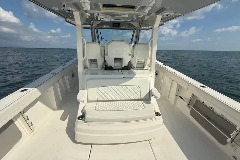 Slide: The Image of 2022 Pursuit S 378 Sport boat interior with seating, on open water under blue sky. - 29