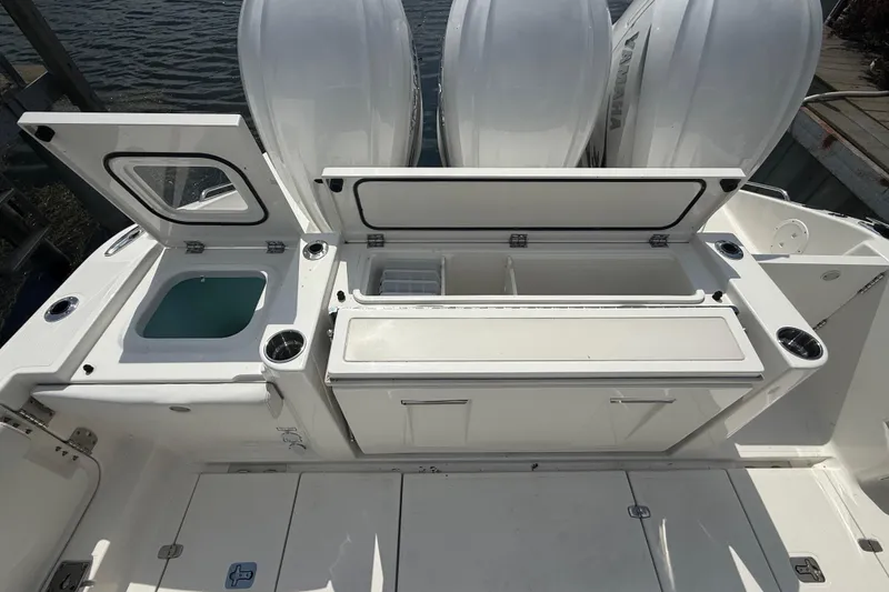 Slide: The Image of 2022 Pursuit S 378 Sport boat deck with storage compartments and outboard engines. - 35