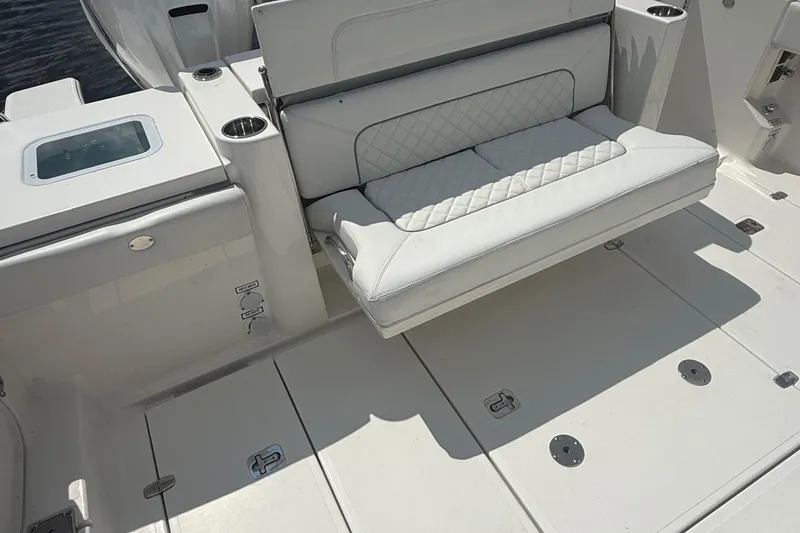 Slide: The Image of 2022 Pursuit S 378 Sport boat interior with white cushioned seating and cup holders. - 37