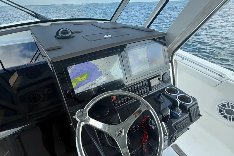 Slide: The Image of 2022 Pursuit S 378 Sport boat helm with navigation screens and steering wheel. - 44