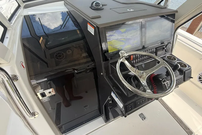 Slide: The Image of 2022 Pursuit S 378 Sport boat cockpit with dual screens and steering wheel. - 48