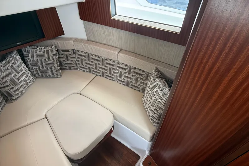 Slide: The Image of 2022 Pursuit S 378 Sport cabin interior with cushioned seating and patterned pillows. - 51