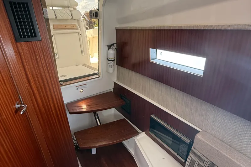 Slide: The Image of 2022 Pursuit S 378 Sport cabin interior with wooden accents and seating. - 52