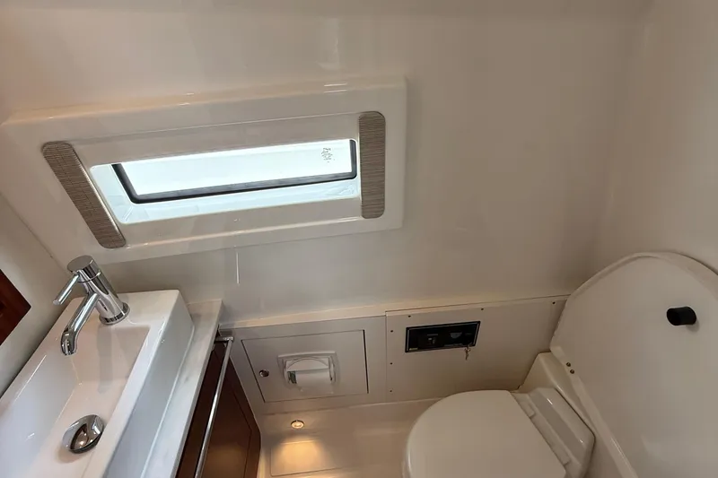 Slide: The Image of 2022 Pursuit S 378 Sport boat bathroom with sink, toilet, and window. - 55