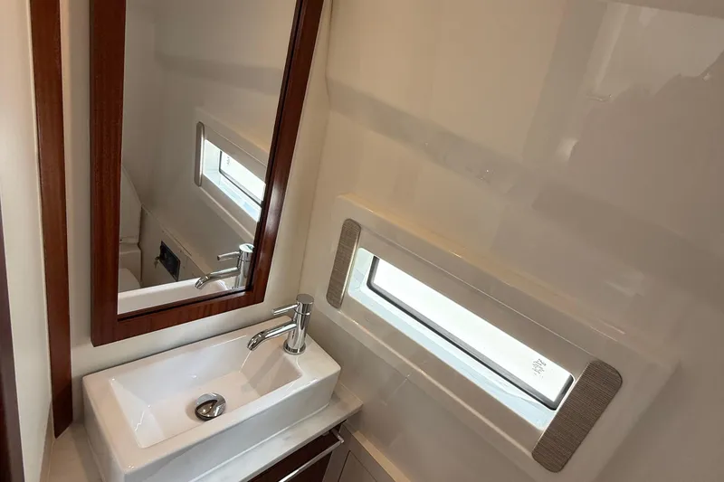 Slide: The Image of 2022 Pursuit S 378 Sport boat bathroom with modern sink, mirror, and window. - 56