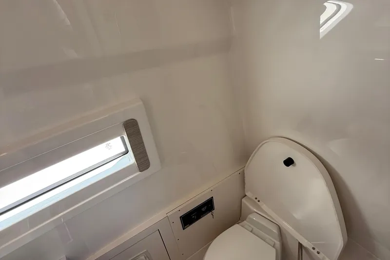 Slide: The Image of 2022 Pursuit S 378 Sport boat interior bathroom with window and toilet. - 57