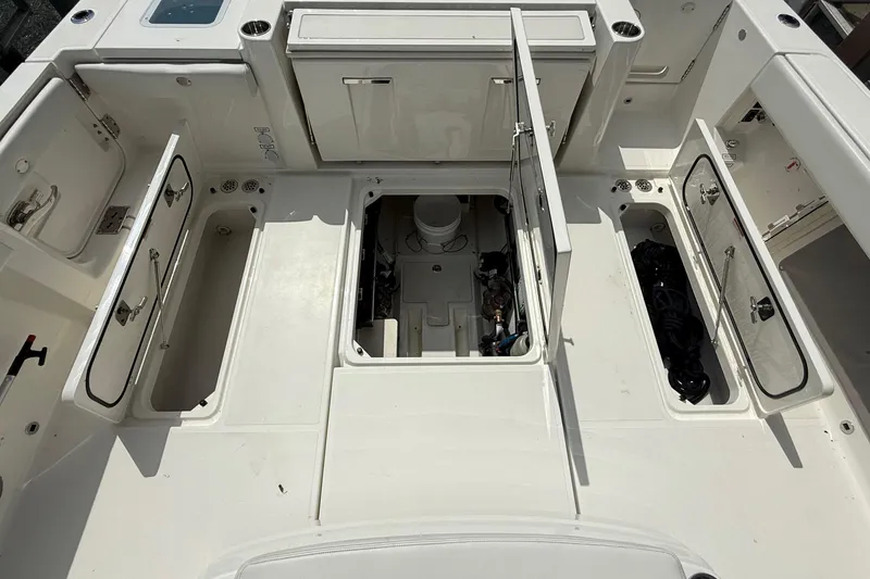 Slide: The Image of 2022 Pursuit S 378 Sport boat deck with open storage compartments and engine access. - 60